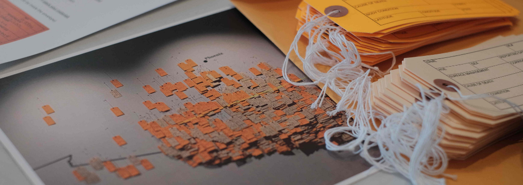 stack of tags and photograph of HT94 installation sitting on table top together