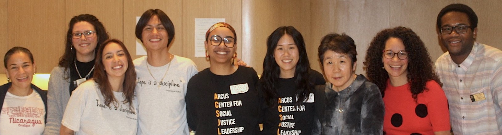 Nine members of the Arcus Center staff standing in a line and smiling. 