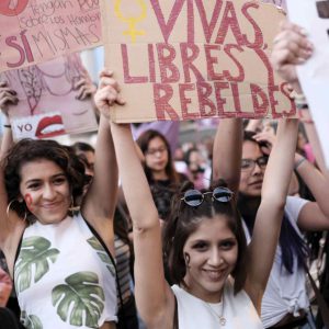 Latinas marching with a sign that reads, "Vivas libres y rebeldes."